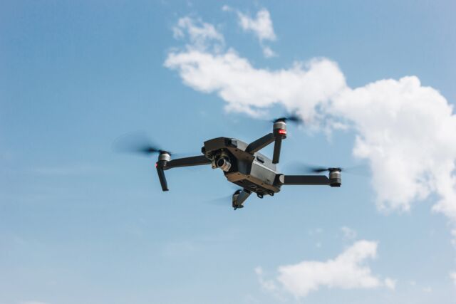 Dron z kamerą w locie na tle nieba